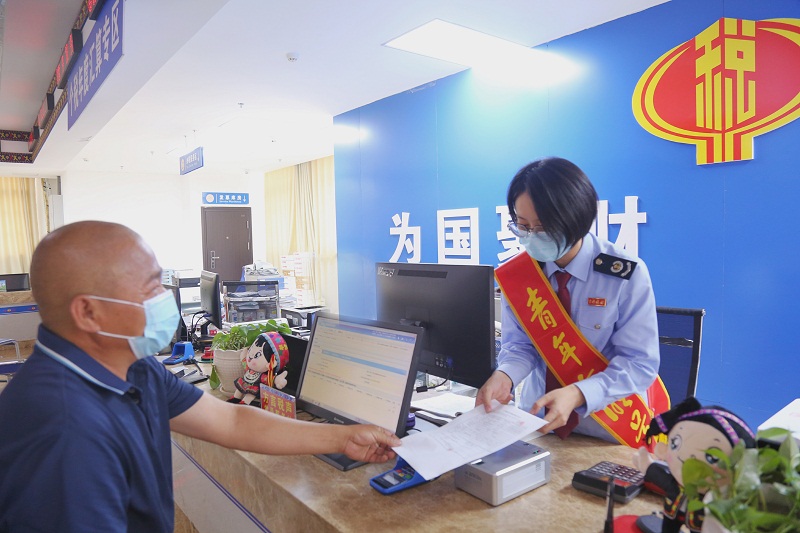 图为大化县税务局青年干部在“方言税声”青年服务岗为纳税人缴费人办理业务.jpg